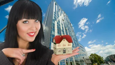 Woman holding mini house, thinkstock 