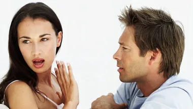A couple engaged in an intense conversation; the woman appears upset while the man listens attentively.