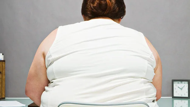 Overweight woman sitting backfaced in chair