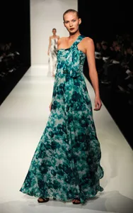 Model on runway in turquoise floral gown during Australian Fashion Week.
