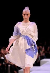 Model in a flowing white and blue dress walks the runway at L'Oréal Melbourne Fashion Festival.