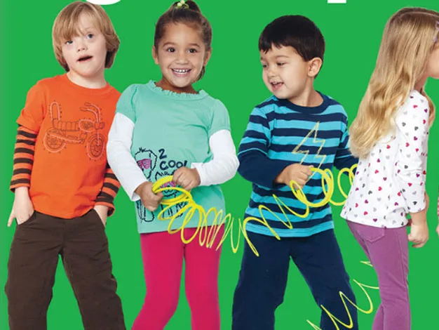 Four children smiling and standing in a row, wearing colorful outfits, against a green background.