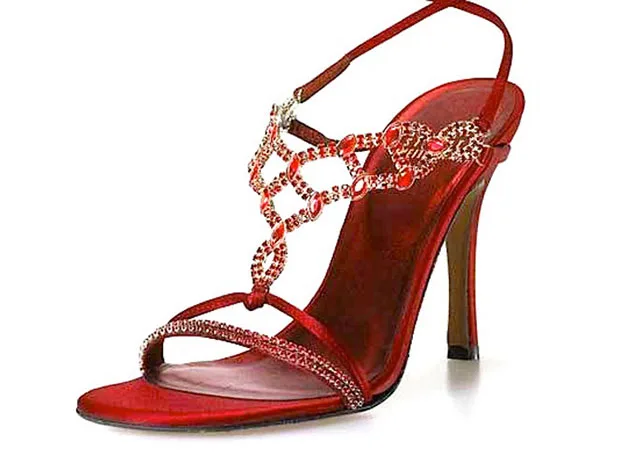 Red high-heeled sandal adorned with intricate crystal embellishments and a thin ankle strap.