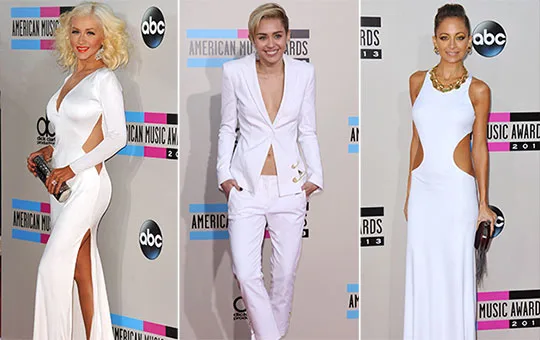 Three celebrities in white outfits on the 2013 American Music Awards red carpet.