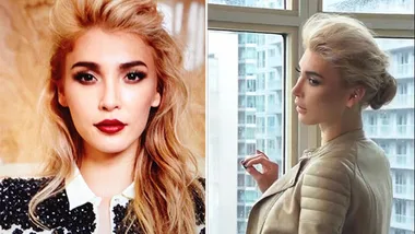 Transgender model poses confidently indoors with striking makeup, showcasing elegance and poise.