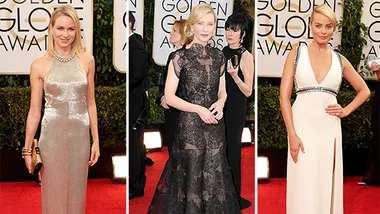 Three elegantly dressed women on the red carpet at the 2014 Golden Globes, in glamorous gowns with award signage behind.