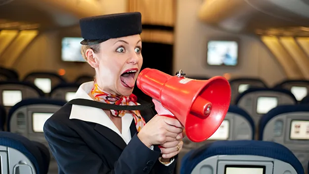 Flight attendant humorously shouts into megaphone on empty plane, expressing annoyance with passengers.