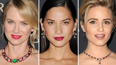 Women pose at Bulgari gala, wearing elegant jewelry, with dark background.