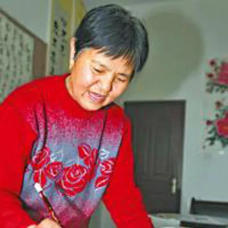 A person in a red sweater is painting with a brush in a room decorated with floral artwork on the walls.