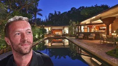 Outdoor view of modern house with pool at night; man with light beard in foreground.
