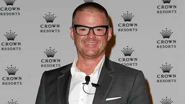 Chef Heston Blumenthal at a Crown Resorts event, wearing glasses and a suit, smiling.