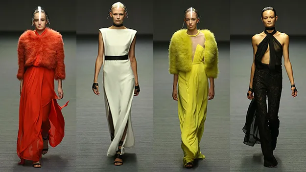 Four models walk the runway in bold outfits featuring vibrant red, white, yellow, and black designs at a fashion show.