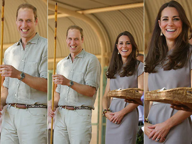 A smiling man in a beige outfit holding a spear, and a woman in a gray dress holding a basket, both in an outdoor setting.