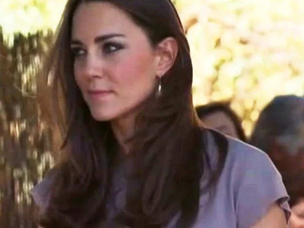 I don’t know who this is, but the image shows a woman with long brown hair in a gray top, outdoors.
