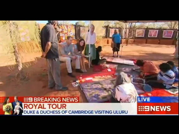 Breaking news segment showing Duke and Duchess of Cambridge visiting artists working on paintings in Uluru.