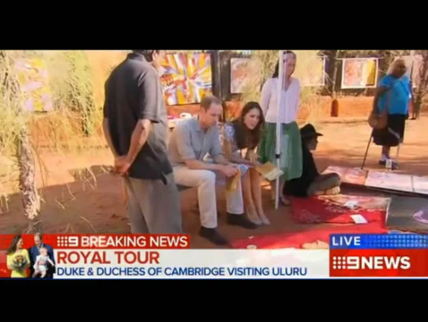 Duke and Duchess of Cambridge sitting and engaging with locals at an outdoor event during Uluru visit, news banner visible.