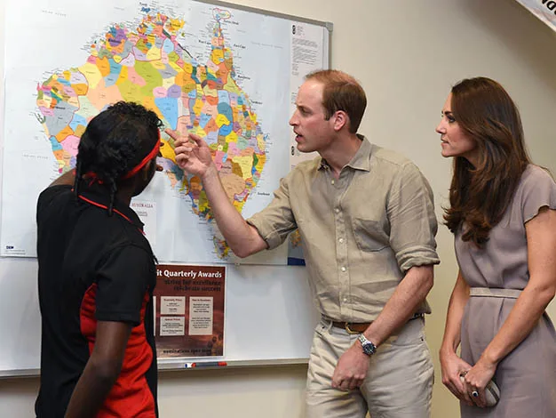 Man pointing at map while woman and another person look on with interest.