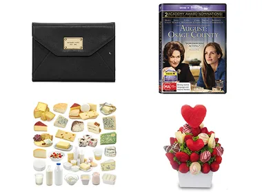 Black clutch, "August: Osage County" DVD, assorted cheeses, and a fruit bouquet with heart-shaped decoration.