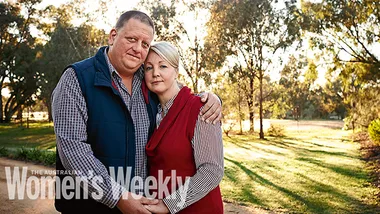 Man and woman embracing outdoors, gazing at camera with trees in background, labeled "The Australian Women's Weekly."