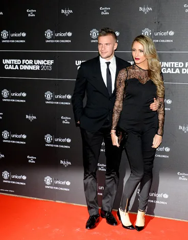 A man in a suit and a woman in a lace top pose on the red carpet at the 2013 UNICEF Gala Dinner.