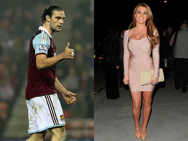 Man in maroon soccer uniform gives thumbs up; woman in beige dress holds clutch, standing outdoors at night.