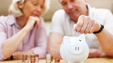 Old man and lady with a piggy bank 