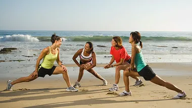 group of women exercising on the beach 