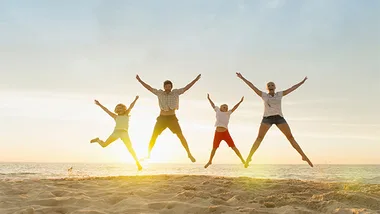 People jumping up in the air sunset beach, stock image 