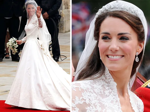 A bride in an elegant lace wedding gown, with a veil and tiara, smiling and waving while holding a bouquet.