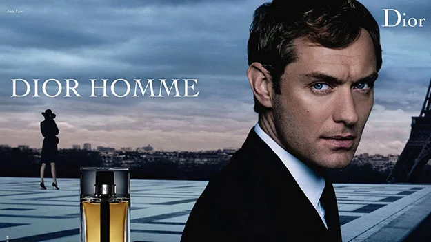 Dior Homme advertisement featuring a man in a suit with a perfume bottle, Eiffel Tower in background.