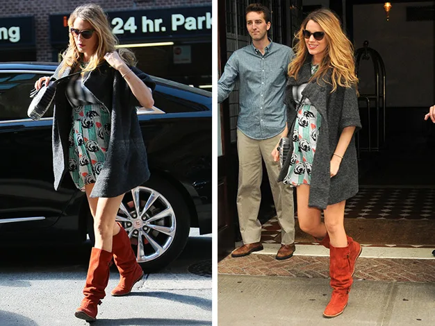 Blonde woman in a patterned dress, gray coat, and red boots exiting a building, with sunglasses on, near a black car.