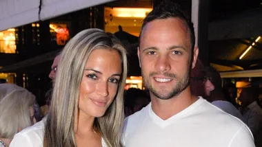 Two people smiling, standing close together at an indoor event.