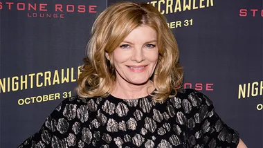 Rene Russo smiling at the "Nightcrawler" premiere, wearing a black and silver patterned dress.