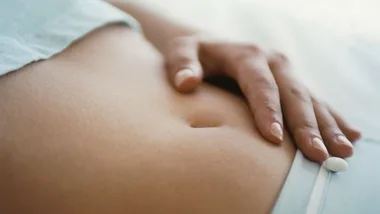 Woman with hand on stomach, stock image 