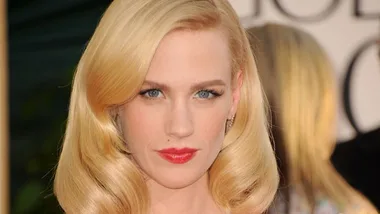 Blonde woman with shiny, elegantly styled hair and red lipstick at a formal event.