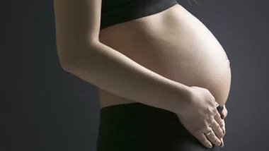 woman's pregnant stomach, getty images 