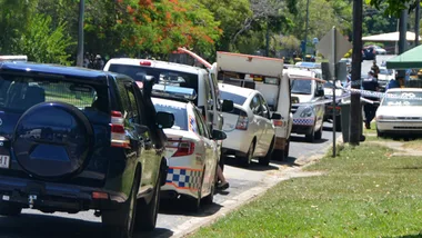 Police vehicles lined up on a street in Cairns, responding to a serious incident.