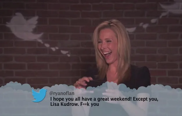 A woman laughs while reading a mean tweet, background has Twitter bird graphics.