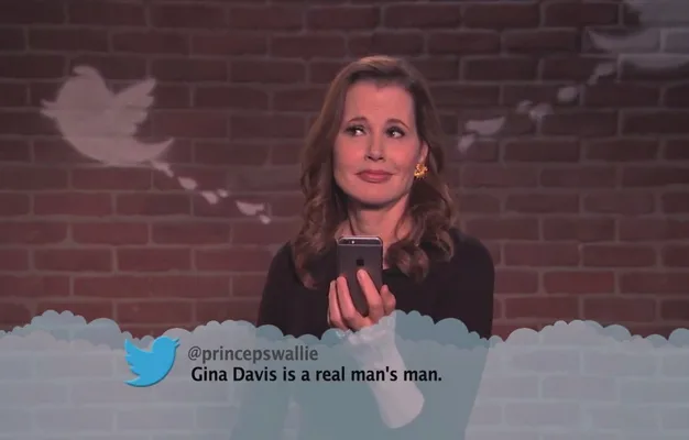 Gina Davis reads a humorous tweet on a show with a brick wall and bird graphic in the background.
