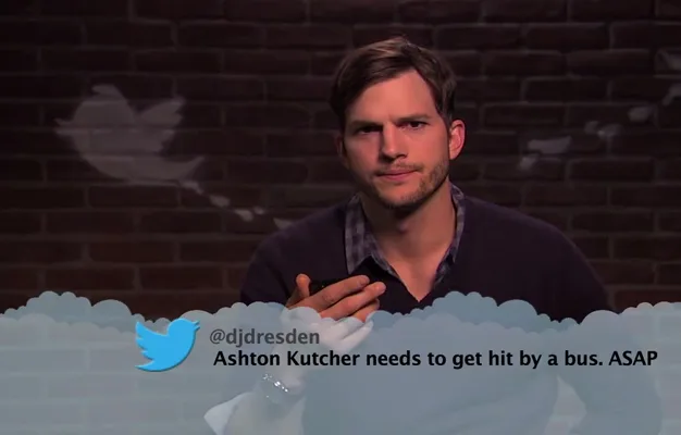 Ashton Kutcher reads a humorous mean tweet about himself on Jimmy Kimmel Live, looking amused.
