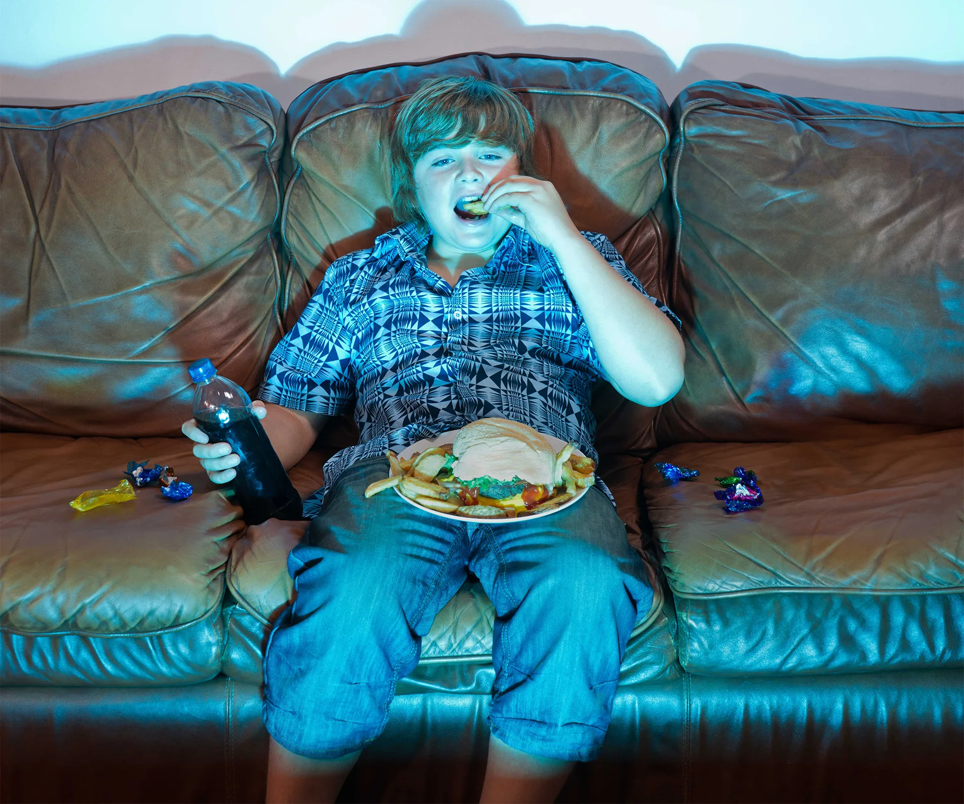 Boy eats food on lounge, stock image