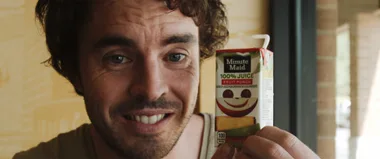 Man smiling, holding Minute Maid Fruit Punch juice box, in "That Sugar Film."