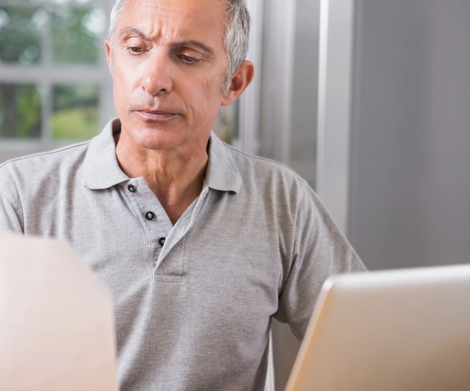 Confused old man reading a piece of paper