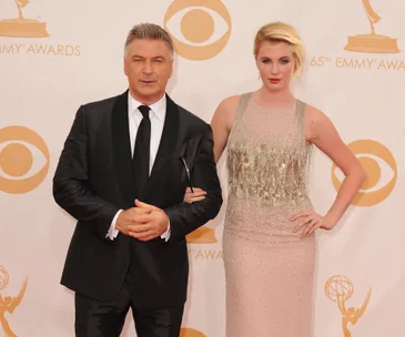 A man in a black suit and woman in a glittery gown pose at the 65th Emmy Awards.