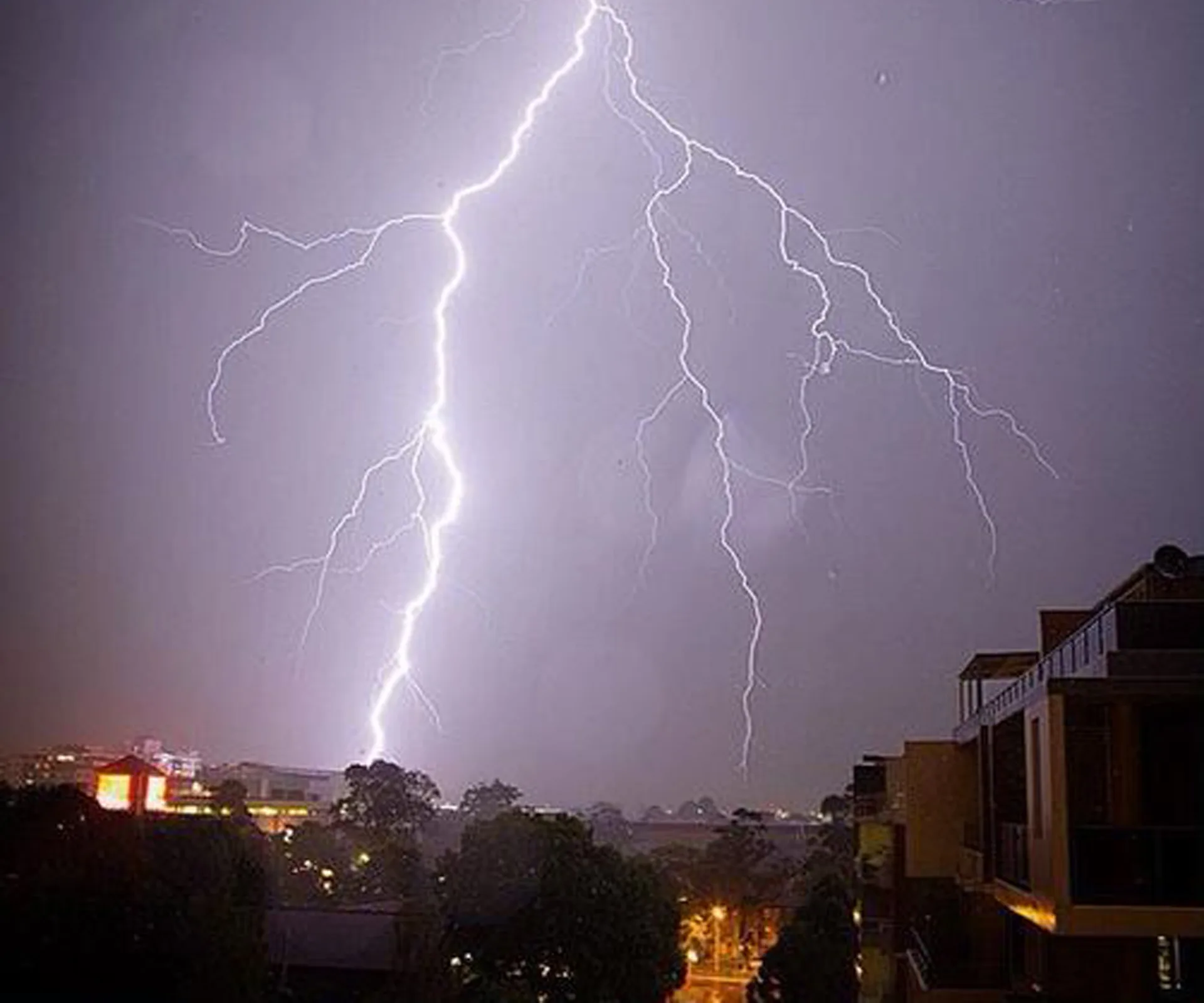 Lightning strikes city buildings at night during a storm in NSW.