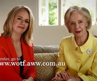 Two women sitting together; one in a red jacket and the other in a yellow jacket, promoting Women of the Future Awards.