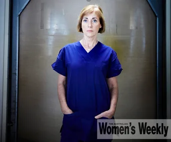 A woman in blue scrubs stands confidently with hands in pockets, against a neutral background. "Women's Weekly" logo displayed.