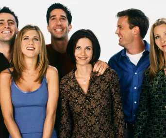 The cast of the TV show "Friends" smiling and posing together.