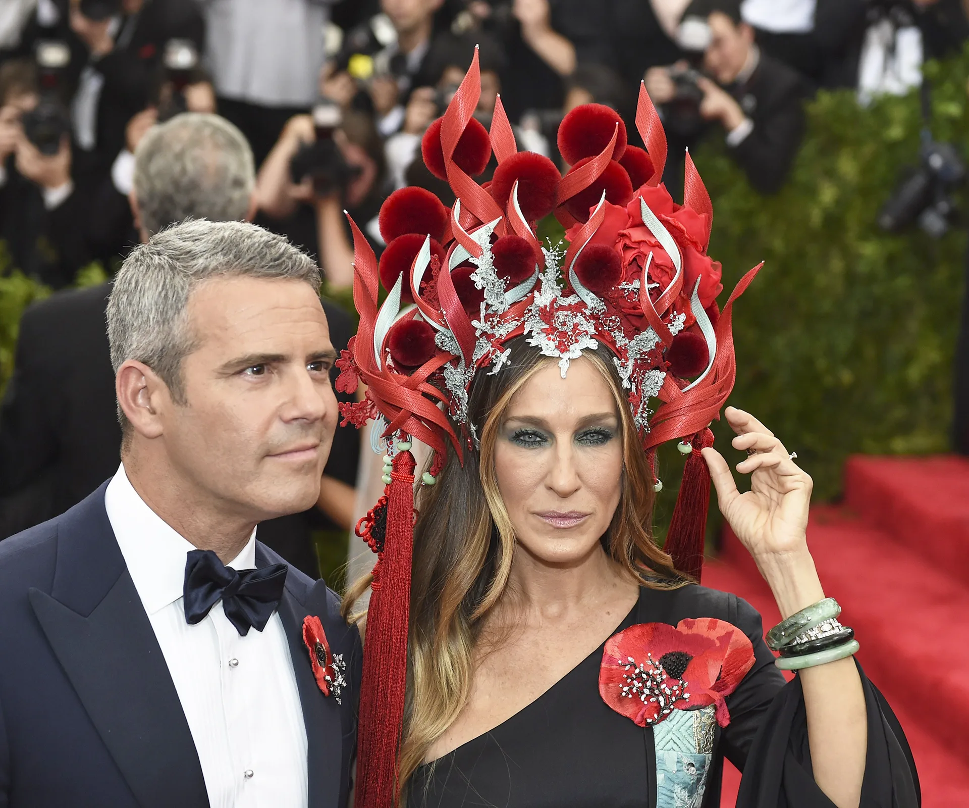 A person wearing an elaborate red and silver headdress, with floral details, at the 2015 Met Gala.