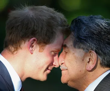 Two men are engaged in a traditional nose press, a gesture of friendship, with serene expressions on their faces.